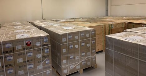 Warehouse of palletised, shrink-wrapped solar panel boxes ready for shipment