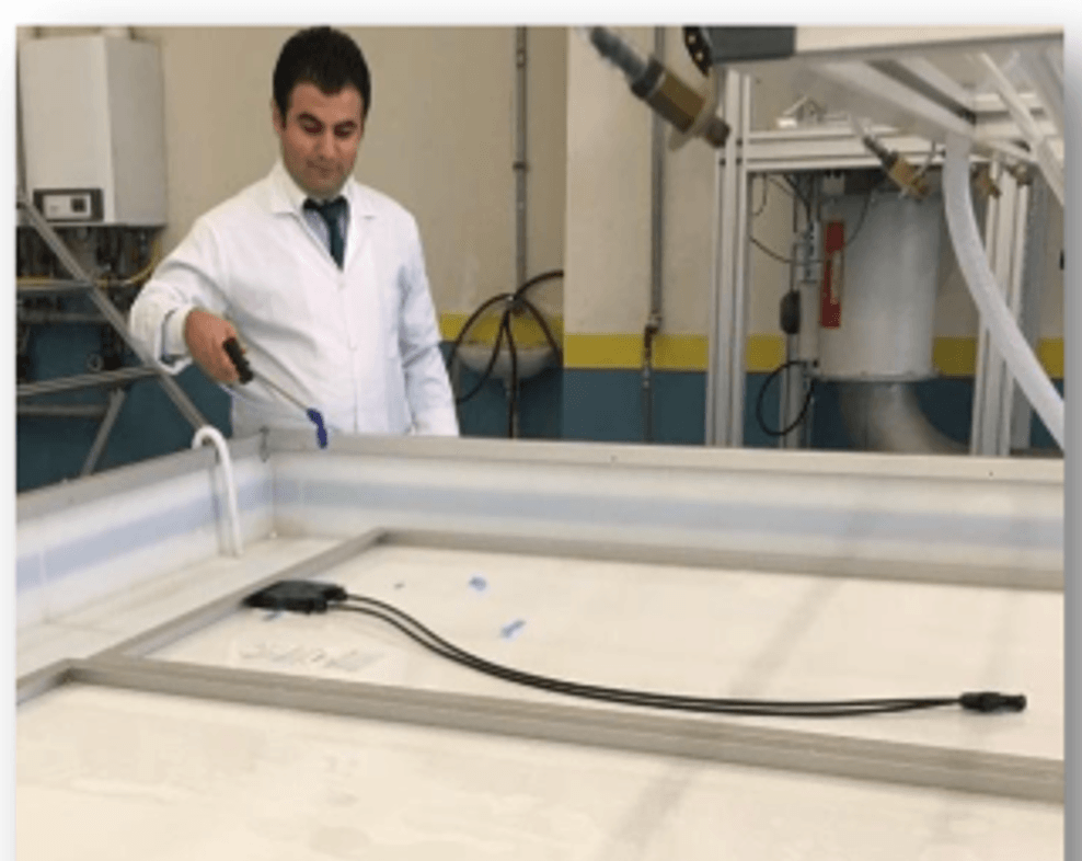 Technician testing a module in a water-filled tray for the wet leakage current test