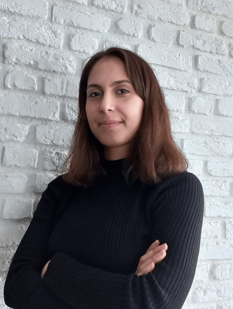 Portrait photo of the article's author standing with arms crossed against a brick wall